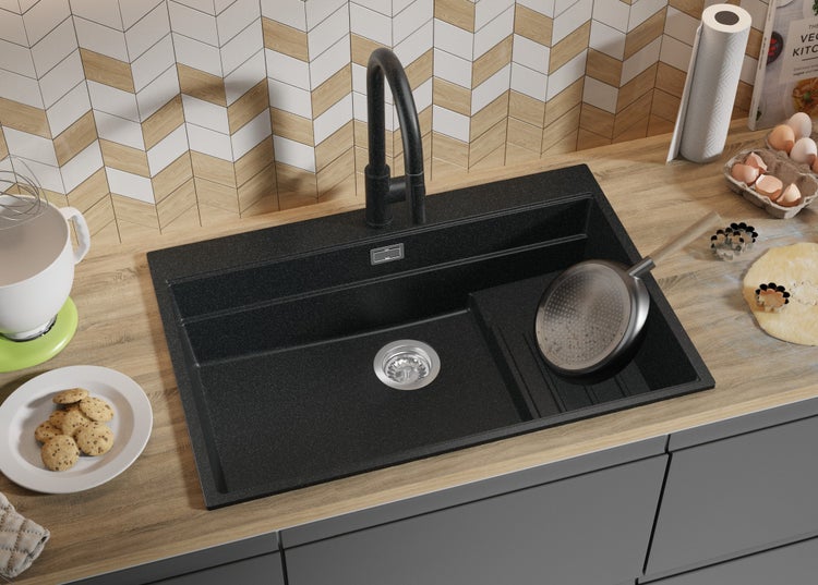 Schwarzes Spülbecken mit Armatur in einer Küchenszenen-Darstellung.