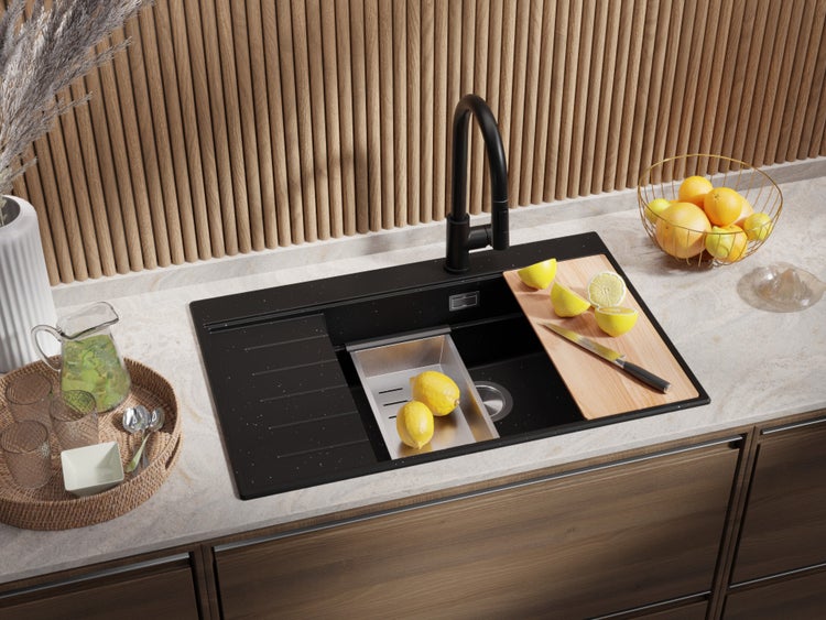 Küchenspüle mit Armatur, Schneidebrett und Abtropfschale auf einer Küchentheke