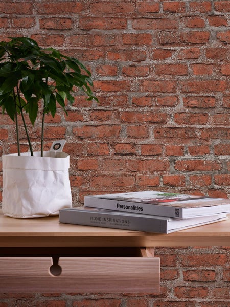 Helle Küche mit Küchentheke, Dekoration und Tafel vor einer Backsteinwand