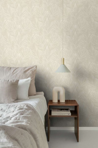Schlafzimmer mit einer Vliestapete mit Palmenblattmotiv, einem Holznachtisch und einer Pendelleuchte in einem modernen und hellen Einrichtungsstil.