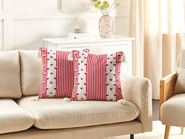 Dekorative Kissen mit Streifenmuster und Herzen auf einem Sofa