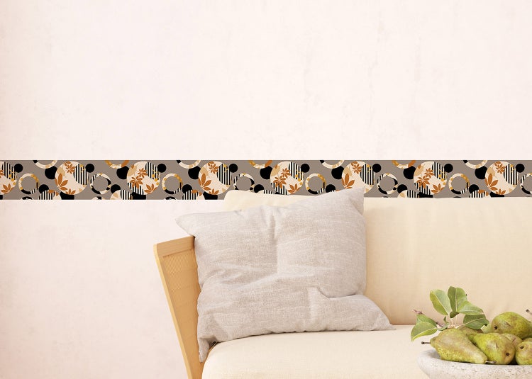 Selbstklebende Wandbordüre mit geometrischem Muster aus Kreisen und Blumenmotiven in einem hellen Wohnzimmer mit Sofa und Holztischen.