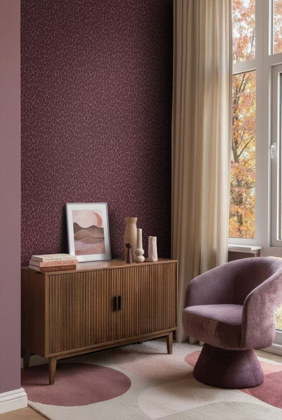 Tapete mit Leopardenmuster in einem modern eingerichteten Raum mit Sideboard aus Holz, Sessel und Teppich mit kreisförmigen Mustern.