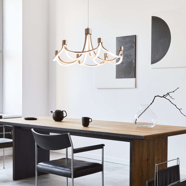 Esstisch-Szene mit moderner Pendelleuchte, Geschirr und minimalistischer Dekoration