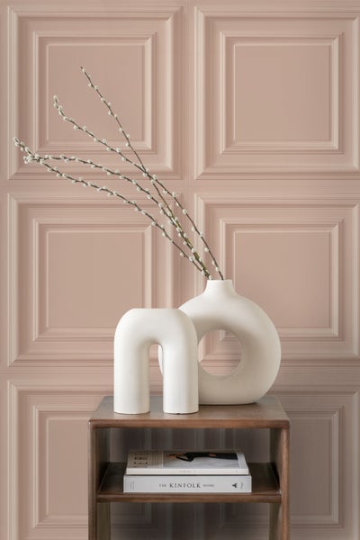 Dekorative Elemente auf einem Beistelltisch vor einer Paneelwand