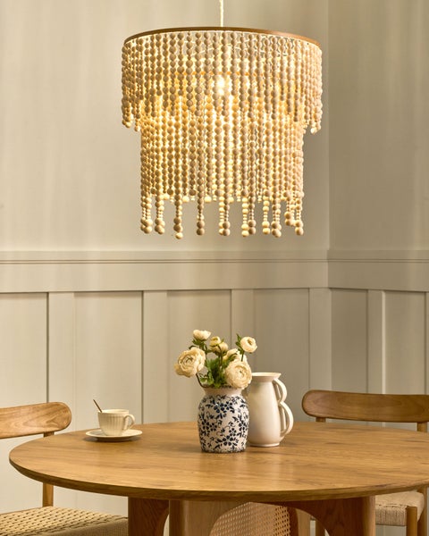 Esszimmer mit Holztisch, Stühlen und einer Hängeleuchte mit Holzperlen