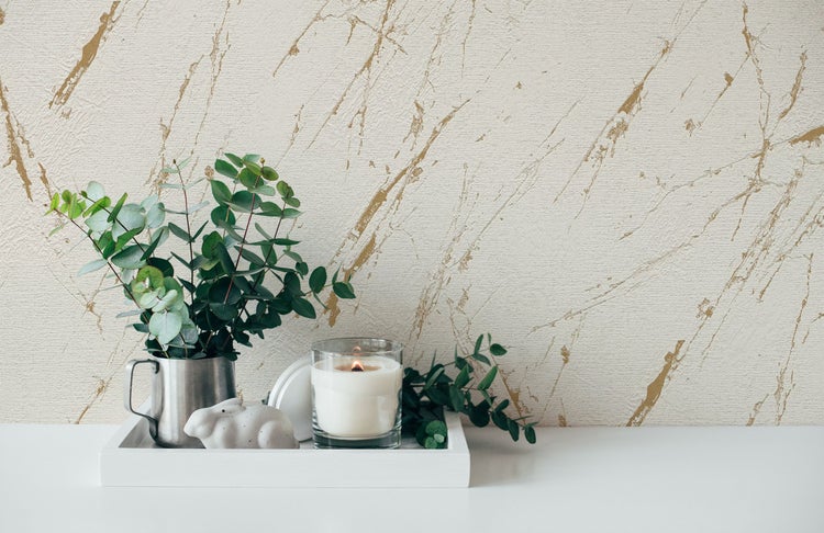 Schlafzimmer mit geometrischer Tapete, Bett und Pflanzen