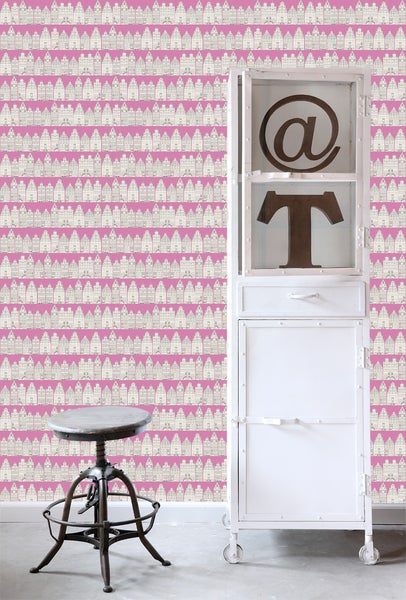 Szene mit einer Wandtapete mit Häusern, einem weißen Metallschrank und einem Hocker.