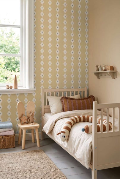 Ein Kinderzimmer mit Vliestapete mit Rautenmuster, einem Holzbett, einem Stuhl in Hasenform und dekorativen Kissen in einer gemütlichen Umgebung.