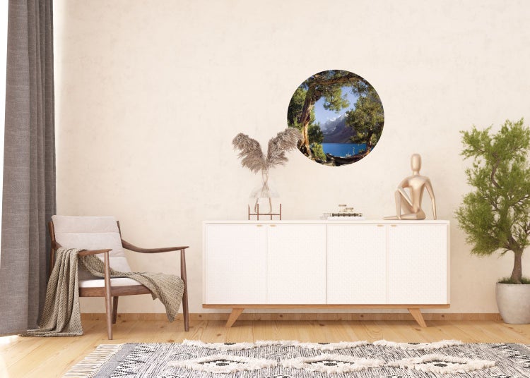 Dekorative Wandgestaltung mit Bergseelandschaft als Wandtattoo über Sideboard im Wohnzimmer.