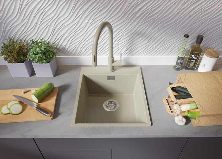 Küchenspüle mit Armatur, Gemüse und Kräutern auf der Arbeitsplatte