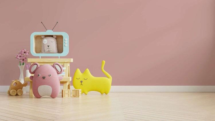 Kinderzimmer-Szene mit einem Holzhocker, Spielzeug-Fernseher, Stofftieren und Holzspielzeug auf Parkettboden vor einer einfarbigen Wand.