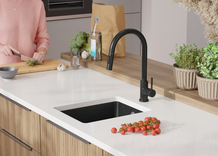 Küchenszene mit Spüle, Armatur und Lebensmitteln auf der Arbeitsplatte.