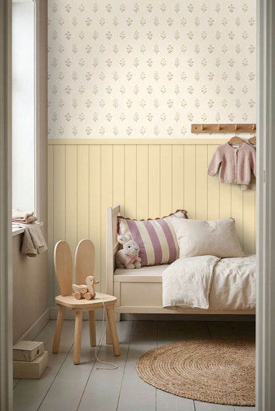 Helles Kinderzimmer mit floraler Tapete, Wandpaneelen aus Holz, Holzbett, Hasenstuhl, Jute Teppich und Kleiderhaken für eine freundliche Atmosphäre.