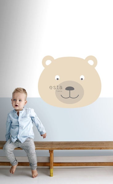 Wandgestaltung mit Bärenmotiv im Kinderzimmer und einem Kind auf einer Bank