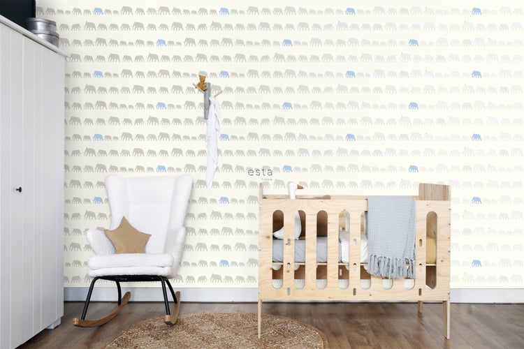 Kinderzimmer mit Elefantentapete, Schaukelstuhl und Kinderbett aus Holz.