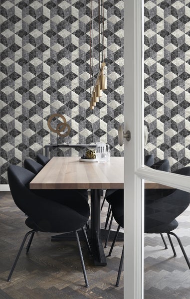 Esszimmer mit Esstisch, Stühlen und einer Wand mit geometrischer Tapete.