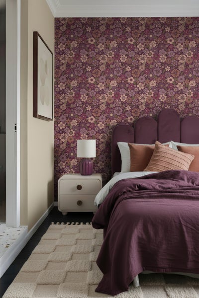 Schlafzimmer mit floraler Tapete, Bett, Nachttisch und Teppich