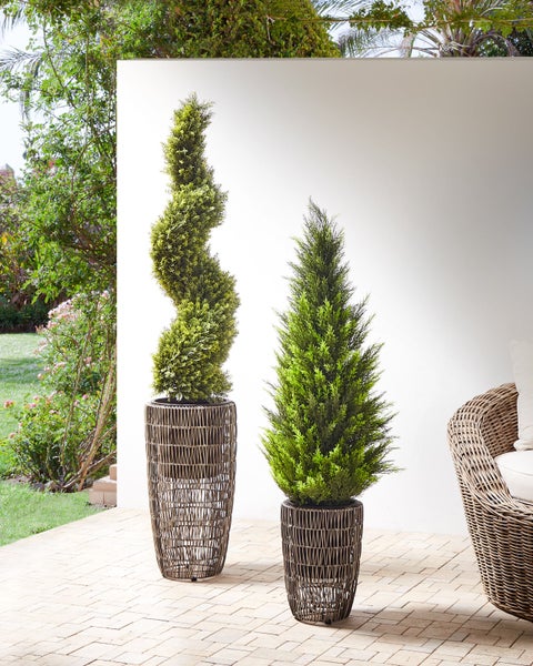 Dekorative Kunstpflanzen im geflochtenen Topf für den Außenbereich.