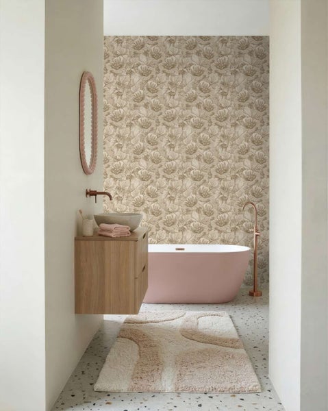Badezimmer mit Blumenmuster Tapete, freistehender Badewanne, hängendem Waschbeckenunterschrank aus Holz und Badematte im modernen Stil.