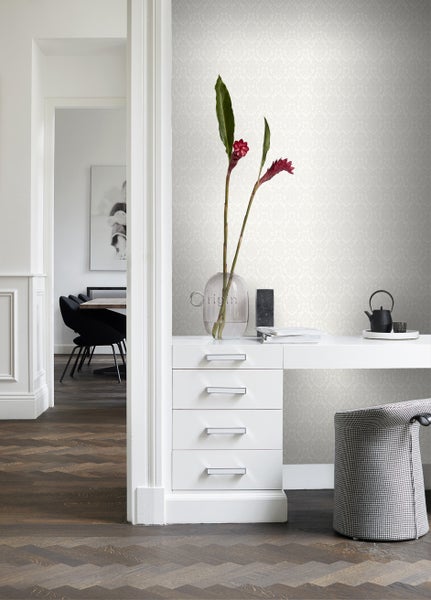 Heller Raum mit gemusterter Tapete, Schreibtisch und Essbereich im Hintergrund