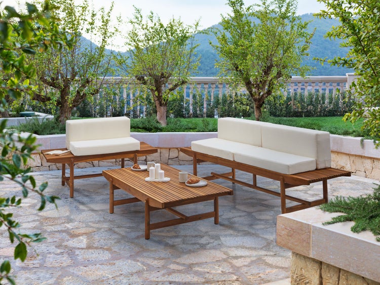 Gartenszene mit Holzsitzgruppe und Kissen auf einer Terrasse