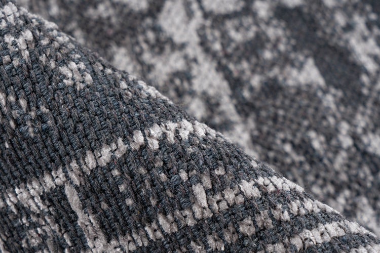 Nahaufnahme eines gewebten Teppichs mit strukturierter Oberfläche und abstraktem Muster.