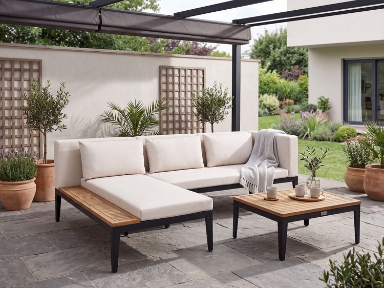 Moderne Loungegarnitur mit Ecksofa und Couchtisch auf einer Terrasse unter einer Pergola, Gartenmöbel aus Metall und Holz mit Polsterauflagen.