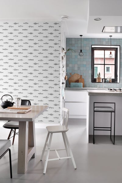 Helle, moderne Küche mit Esstisch, Stühlen, Tapete mit Fischmuster und blau gefliestem Küchenbereich.