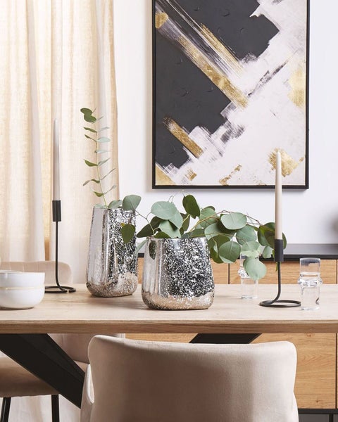 Dekoratives Wohnambiente mit Tisch, Stühlen, Vase und Gemälde