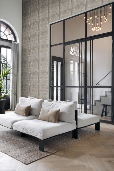 Wohnzimmer mit Sofa, Teppich und Raumteiler im Loftstil