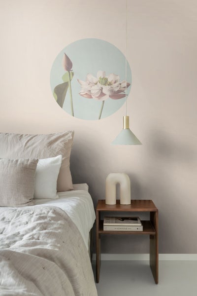 Schlafzimmer mit Bett, Nachttisch, Lampe und Wanddekoration