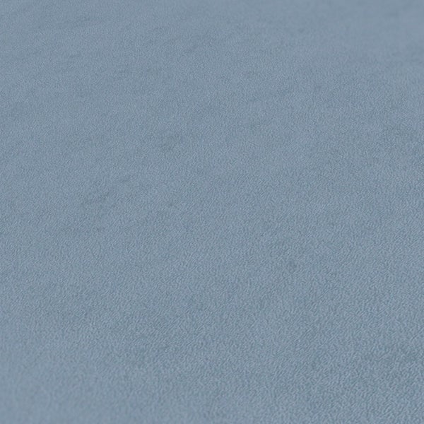 Szene mit Sessel, Beistelltisch und Hängelampe vor einer Wand