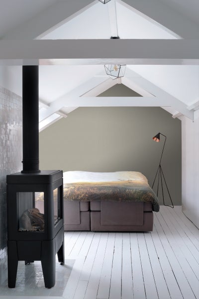 Helles Schlafzimmer mit Kaminofen, Boxspringbett und Stehlampe