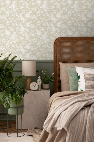 Dekoratives Schlafzimmer mit gemusterter Tapete, Holzbett und Zimmerpflanzen