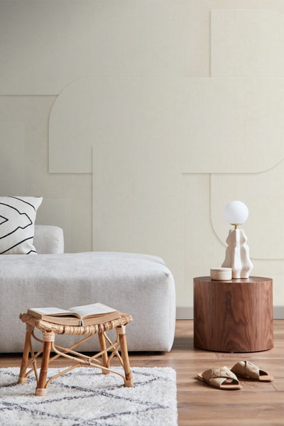 Wohnzimmer mit Sofa, Beistelltisch, Lampe, Teppich und dekorativer Wandgestaltung