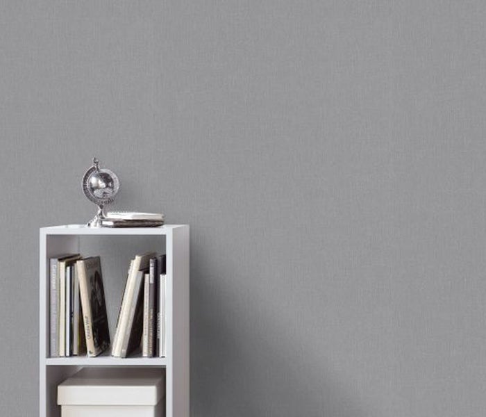 Helles Schlafzimmer mit floral gemusterter Tapete, geöffneter Tür und Bett