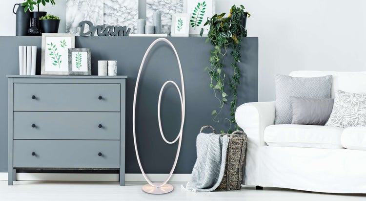 Wohnzimmer mit Kommode, Sofaecke, Korb und LED-Stehlampe