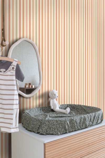 Babyzimmer mit Wickelkommode, Spiegel, Overall und gestreifter Tapete