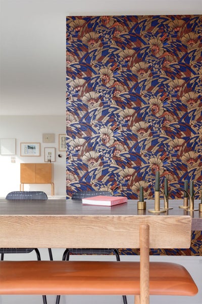 Kinderzimmer mit Wickelkommode, Regal und dekorativen Elementen vor gemusterter Tapete