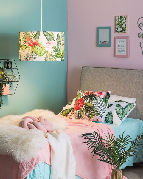 Dekoratives Schlafzimmer mit Bett, Lampe und Wanddekoration