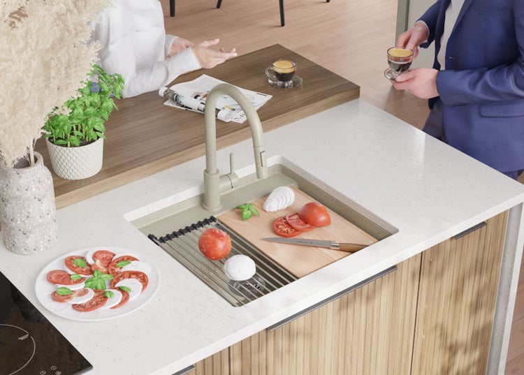 Küchenszene mit Spüle, Armatur, Schneidebrett, Lebensmitteln und zwei Personen