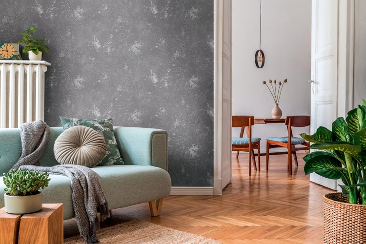 Dekorative Szene mit Pflanze, Bild und Bücher auf einem Tisch vor einer gemusterten Wand