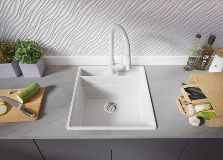 Küchenspüle mit Armatur, Gemüse und Lebensmitteln auf der Arbeitsplatte