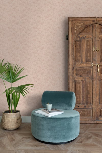 Wohnraumszene mit floral gemusterter Tapete, Sessel, Pflanze und Holztür