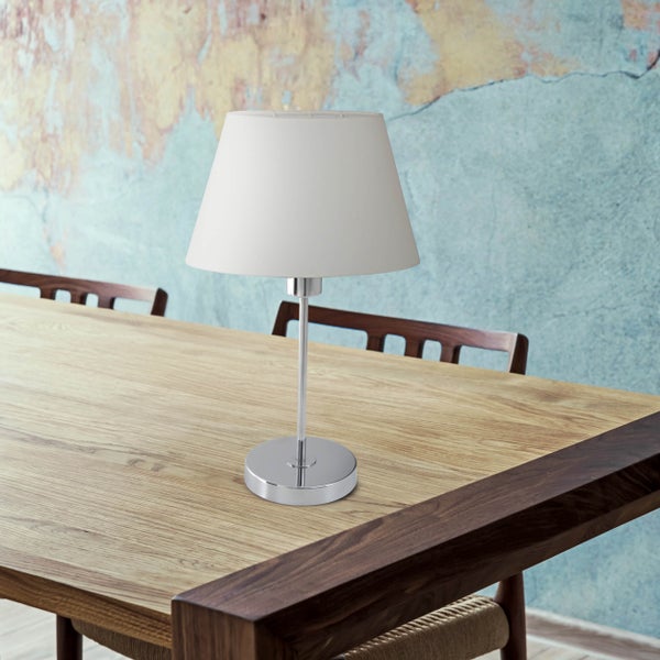 Tischleuchte mit Stoffschirm und Metallfuß auf einem Holztisch