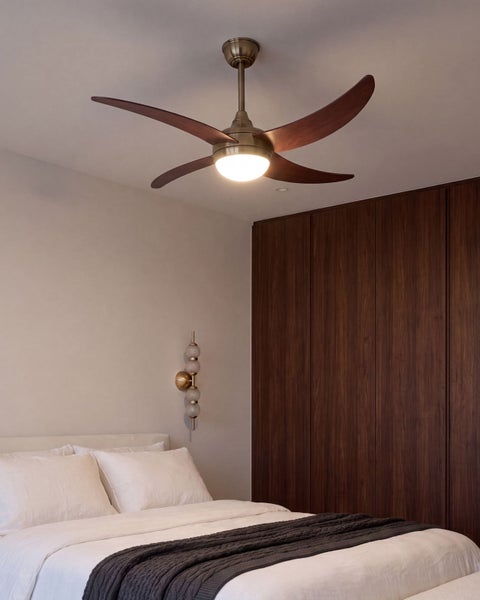 Deckenventilator mit Beleuchtung in einem modern eingerichteten Schlafzimmer mit Holzkleiderschrank und Wandleuchte