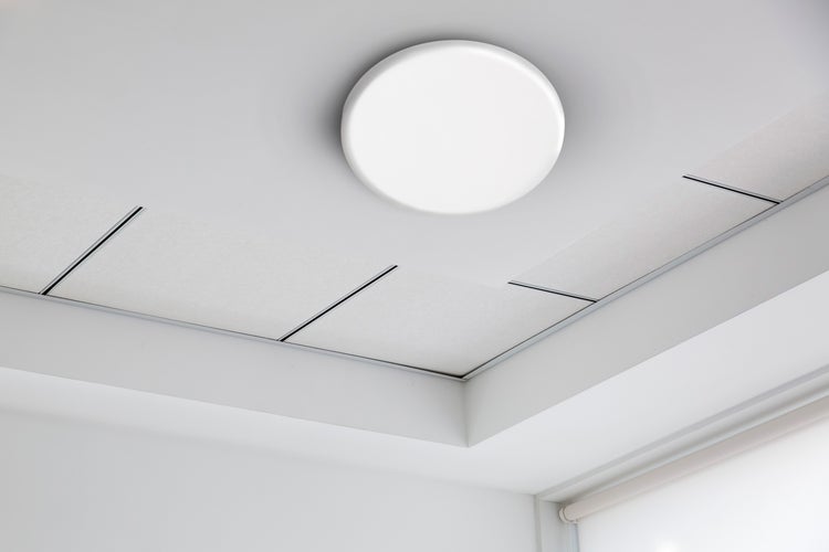 Deckenleuchte und Kassettendecke in einem hellen Raum