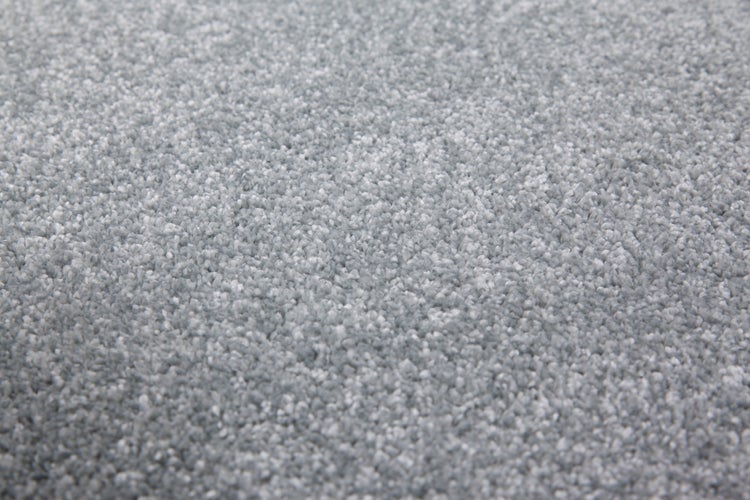 Nahaufnahme eines grauen Hochflor-Teppichs mit weicher Textur.