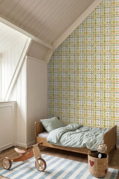 Vliestapete mit Karomuster in einem Kinderzimmer mit Holzmöbeln und Dachschräge.